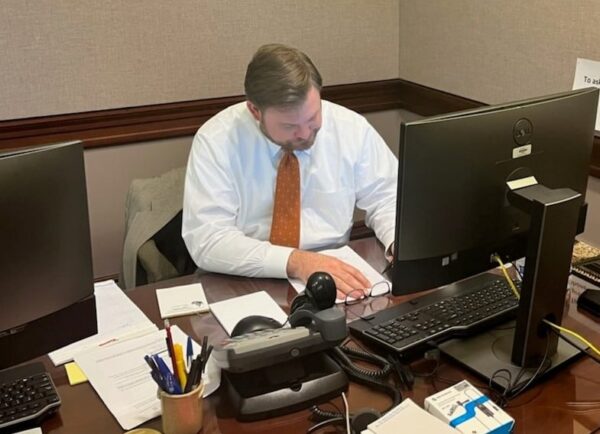 Sen. Pittman sitting behind a desk during a tele-town hall meeting