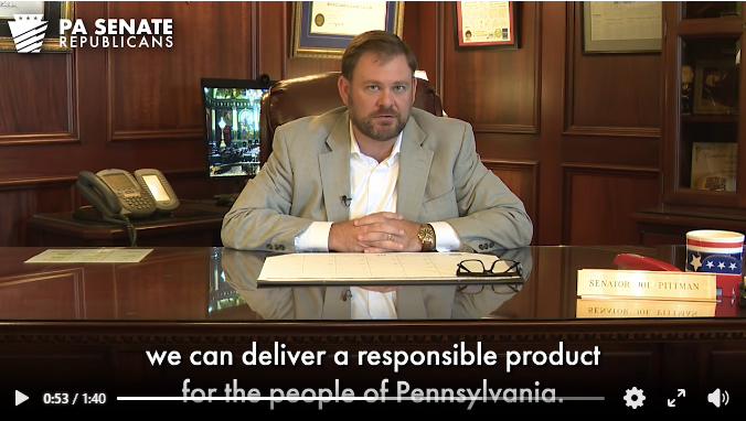 Sen. Pittman pictured sitting behind his desk.